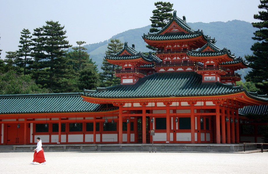 <strong>Heian-Jingu </strong> Este imponente santuário é relativamente recente, tendo sido construído em 1895 em comemoração ao aniversário de 1100 anos da fundação da antiga capital que, antes de se chamar Kyoto, tinha o nome de Heian. Sua arquitetura foi baseada no palácio imperial original da cidade, e um gigantesco torii marca sua entrada. Atrás dos prédios principais se encontra um grande jardim que, em Abril, é um dos melhores pontos da cidade para avisar as flores de cerejeira. O santuário abriga também um dos três principais festivais da cidade, o Jidai Matsuri, quando uma procissão caminha até ele a partir do palácio imperial com roupas típicas de cada um dos períodos históricos do país. Uma curiosidade: é possível ver o santuário no filme de Sofia Coppola Encontros e Desencontros, quando a personagem de Scarlett Johansson faz uma viagem a Kyoto.