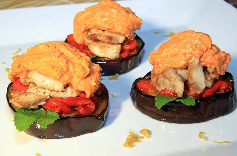 Rodelas de beringelas assadas, cobertas com aioli de pimentão vermelho e fatias de peixe branco