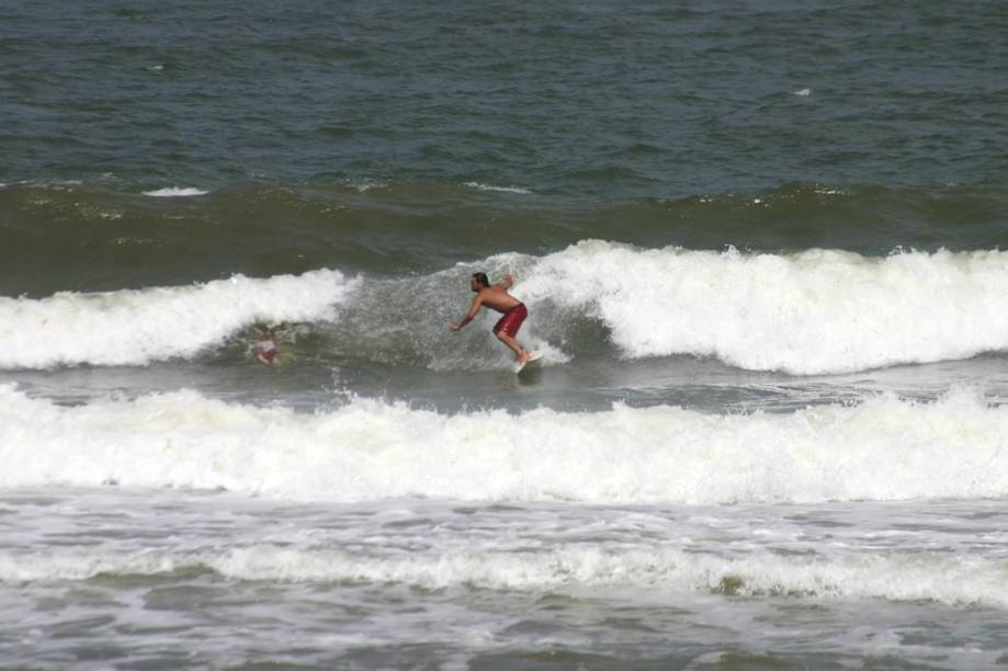 Surfista na Praia do Rezende, que tem pequena faixa de areia e é cercada por coqueiros Surfista na Praia do Rezende, que tem pequena faixa de areia e é cercada por coqueiros