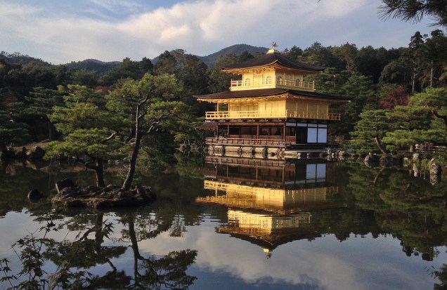 <strong>Kinkaku-ji (Rokuon-ji) </strong> Apelidado de “pavilhão dourado”, é com certeza uma das construções mais bonitas da cidade. Antiga “casa de repouso” do shogun (antigo chefe de estado) Ashikaga Yoshimitsu, foi transformado em templo budista após sua morte em 1408. Com os dois andares superiores inteiramente revestidos por folhas de ouro, o pavilhão literalmente brilha ao refletir a luz do sol, e tem o efeito maximizado pelo reflexo no lago a sua volta. A construção já foi destruída por dois incêndios, mas foi reconstruída a cada vez – a estrutura atual data de 1955.