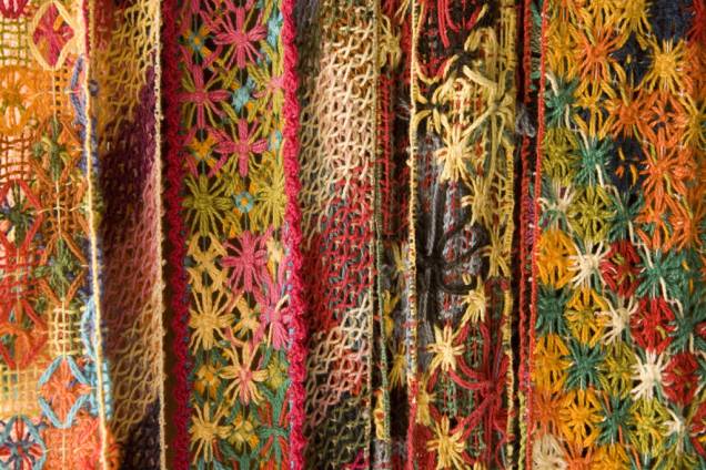 Nas lojas de vitrine colorida do bairro Pontal da Barra, o algodão, matéria-prima do bordado conhecido como filé, vira arte