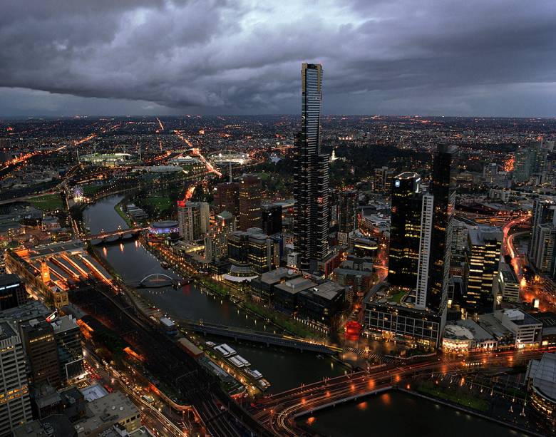 Vista de parte do centro de Melbourne, com o Victoria Gardens, Kings Domain e o Parque Olímpico se espalhando às margens do rio Yarra Vista de parte do centro de Melbourne, com o Victoria Gardens, Kings Domain e o Parque Olímpico se espalhando às margens do rio Yarra