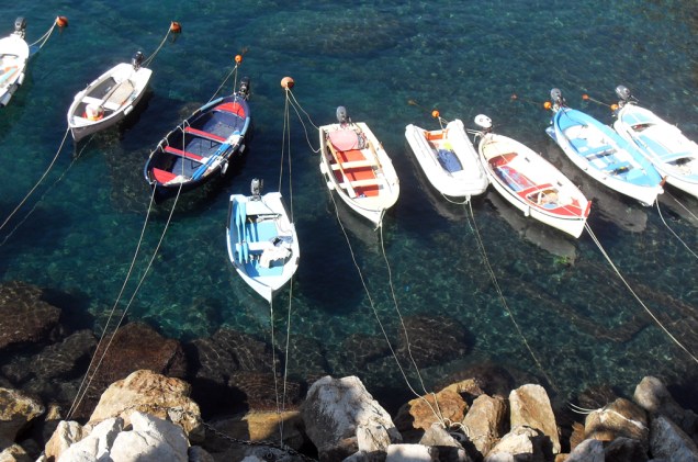 Vista do mar esmeralda e seus barcos de pescadores na cidade de Manarola, Região de Cinque Terre, Itália