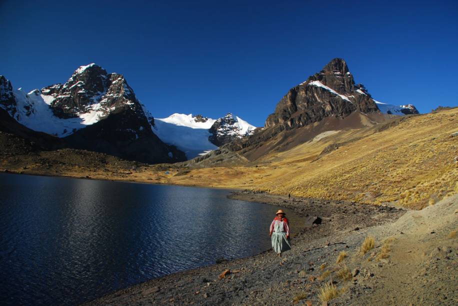 Mulher caminha na beira do lago, do Parque nacional de Condoriri, Bolívia  Mulher caminha na beira do lago, do Parque nacional de Condoriri, Bolívia
