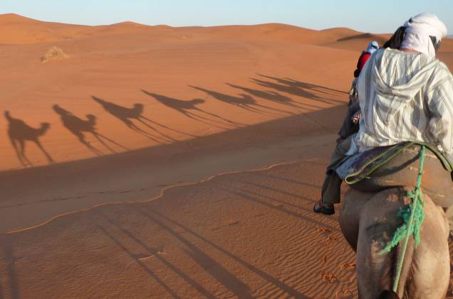Uma das atividades turísticas do deserto marroquino é passear de camelo
