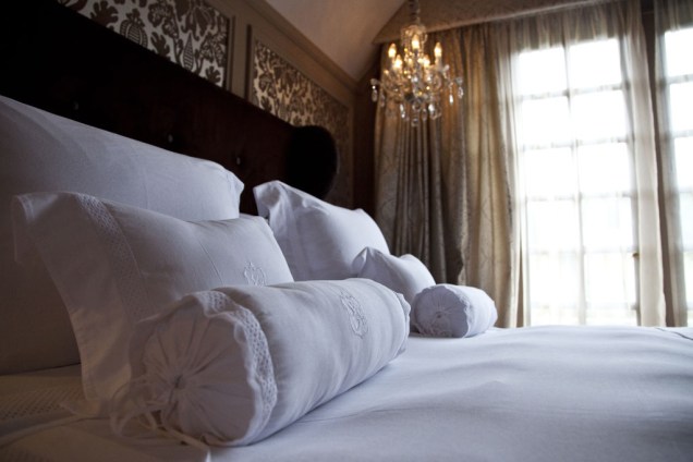 Detalhe da cama de um dos quartos do hotel, que conta com menu de travesseiros e enxoval de primeiríssima linha