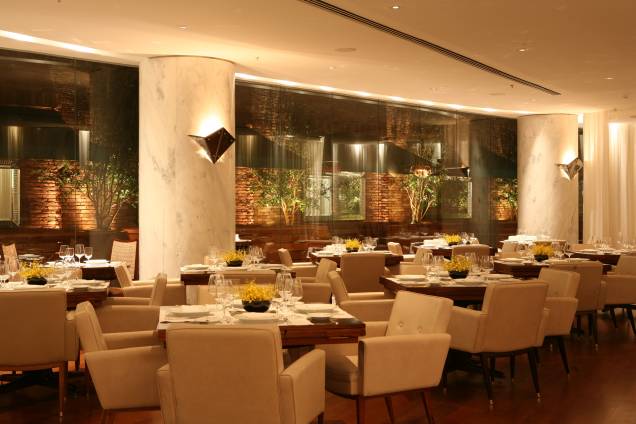 O salão do restaurante Fasano Al Mare, no Rio de Janeiro, possui mesas de jacarandá, poltronas com pés palito e colunas de mármore branco nacional