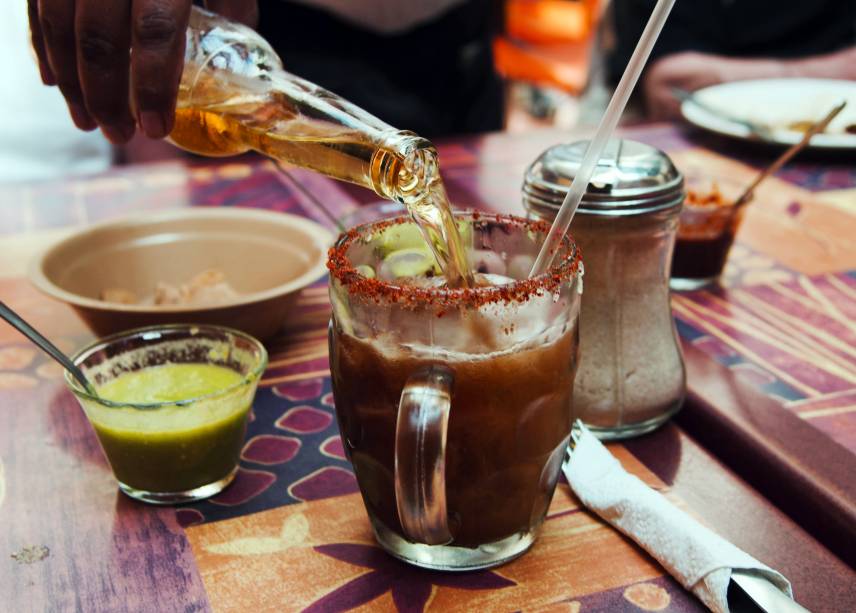 <strong>6. Michelada – <a href="https://viajeaqui.abril.com.br/paises/mexico" rel="México " target="_blank">México</a> </strong>                    Popular em todo México, o nome michelada vem de “mi chela helada”, ou “minha cerveja gelada”. Antes da popularização dos refrigeradores era comum colocar uns cubos de gelo na cerveja – e por que não um pouco de pimenta e limão, como tudo na culinária mexicana? Com o tempo, a receita foi se aperfeiçoando para incluir molho inglês e outros molhos prontos (como de soja e maggy), além de suco de tomate. Em algumas cidades, a mistura da michelada com molho de tomate se chama cubana, mas você não vai encontrar esse drink em Cuba. Em muitos bares na <a href="https://viajeaqui.abril.com.br/cidades/mexico-cidade-do-mexico" rel="Cidade do México" target="_blank">Cidade do México</a>, a mistura secreta da michelada perfeita é chamada de “petróleo” e já fica pronta em uma jarra, para ser acrescentada à cerveja na hora de servir.                    <strong>Experimente em casa:</strong> as receitas variam muito e é tudo feito no “olhômetro”, mas aqui vai o princípio das coisas para ir treinando até achar sua mistura ideal: em um copo alto, faça uma borda de limão, sal e pimenta em pó. Sirva cerveja clara até três dedos abaixo da borda, acrescente suco de um limão pequeno, meia colher de chá de molho de pimenta, meia colher de chá de molho inglês e, se estiver se sentindo caribenho, um pouquinho de suco de tomate.