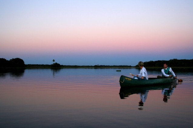 Após um dia cansativo, não há nada melhor do que um passeio de canoa para ver o pôr do sol. Na estação da cheia no Pantanal (MT e MS), o evento se torna ainda mais bonito graças ao espelho formado pela água, que inunda a planície 