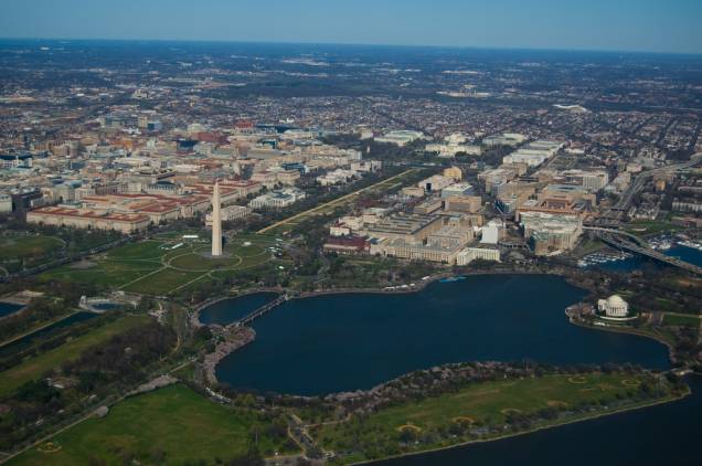 Vista aérea de Washington DC. O National Mall é o eixo de parques e monumentos entre o Capitólio e o Lincoln Memorial, com o obelisco em homenagem a Washington mais ou menos em seu centro. Em primeiro plano, o Tidal Basin, com o Jefferson Memorial às suas margens (à direita)