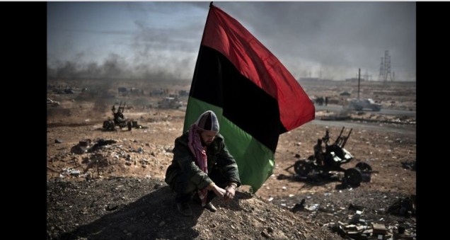 Um resto de caça oposição sob uma bandeira rebelião no meio do campo de batalha óleo cidade Ras Lanouf, na <strong>Líbia</strong>. A foto foi vencedora da categoria Notícias Gerais (reportagem)