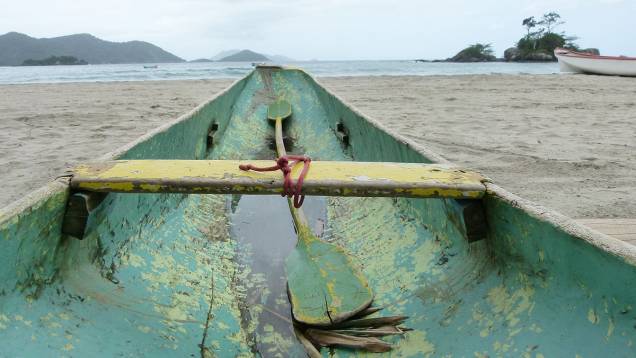 Barco de caiçara desponta em direção ao mar, na Praia de Castelhanos