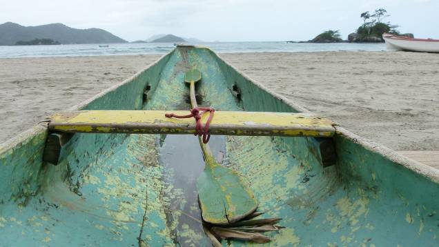 Barco de caiçara desponta em direção ao mar, na Praia de Castelhanos Barco de caiçara desponta em direção ao mar, na Praia de Castelhanos