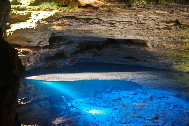 <strong>10. Poço Encantado (Itaetê)</strong> Localizando dentro de uma caverna, o poço tem águas transparentes. Não é permitido entrar nas águas. O poço ganha tons azulados quando o sol incide por uma fenda, de abril a setembro, entre 10h e 12h. <em><a href="https://www.booking.com/searchresults.pt-br.html?aid=332455&sid=8118a1a04f2fb6081078124dc7c2384f&sb=1&src=index&src_elem=sb&error_url=https%3A%2F%2Fwww.booking.com%2Findex.pt-br.html%3Faid%3D332455%3Bsid%3D8118a1a04f2fb6081078124dc7c2384f%3Bsb_price_type%3Dtotal%26%3B&ss=Chapada+Diamantina%2C+Brasil&is_ski_area=&checkin_monthday=&checkin_month=&checkin_year=&checkout_monthday=&checkout_month=&checkout_year=&no_rooms=1&group_adults=2&group_children=0&map=1&b_h4u_keep_filters=&from_sf=1&ss_raw=Chapada+Diamantina&ac_position=0&ac_langcode=xb&dest_id=5235&dest_type=region&place_id_lat=-12.670709&place_id_lon=-41.43712&search_pageview_id=1b048a1f08110174&search_selected=true&search_pageview_id=1b048a1f08110174&ac_suggestion_list_length=5&ac_suggestion_theme_list_length=0#map_closed" target="_blank" rel="noopener">Busque hospedagens na Chapada Diamantina</a></em>