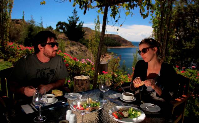 Casal desfruta de almoço no terraço do Isla Suasi, hotel exclusivo na ilha homônima do Lago Titicaca, única de propriedade particular no pedaço