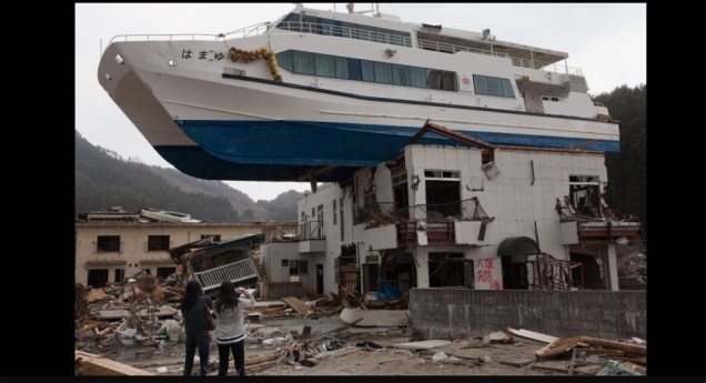 Nozomi Sabanai (esquerda), juntamente com sua irmã, olha para um barco de passeio de catamarã que foi lançado pelo <strong>tsunami</strong> em um prédio de dois andares, em Otsuchi cidade, prefeitura de Iwate,<strong> Japão</strong>. A foto foi vencedora da categoria Pessoas nas notícias (reportagem fotográfica)