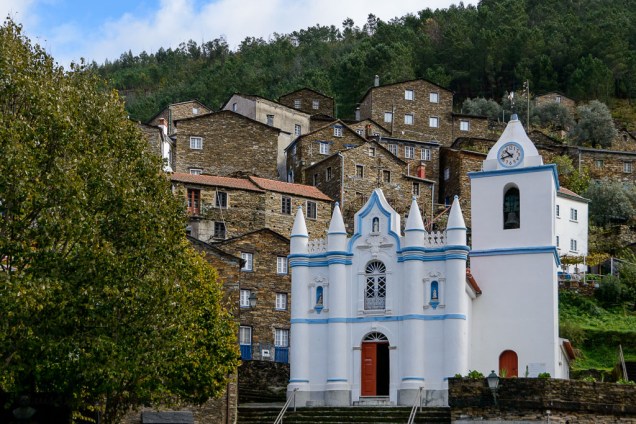 Aos pés da Serra do Açor, o pequeno povoado de <strong>Piodão </strong>ergue-se com casinhas de xisto e uma igreja pintada de branco que se destaca na paisagem. Ela é chamada de “Aldeia Presépio” e considerada uma das cidades mais típicas de Portugal