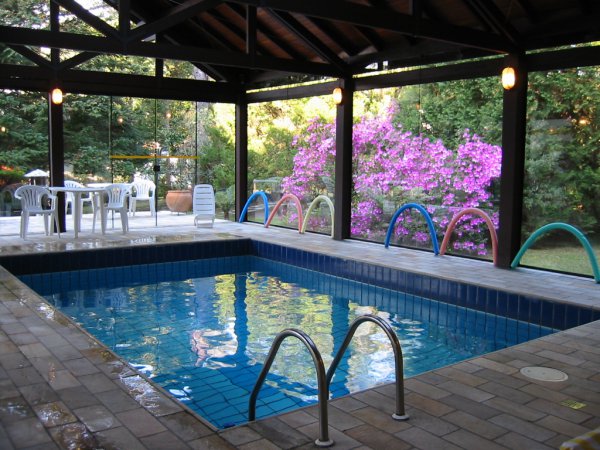 Na área de lazer do Grande Hotel Campos do Jordão, a piscina é aquecida e coberta por um telhado de vidro