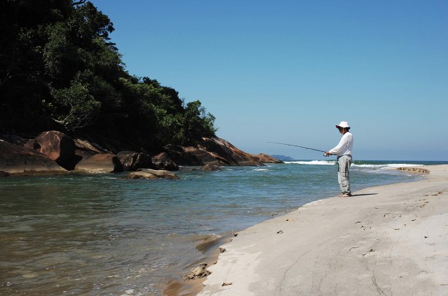 Homem pesca no rio Puruba, que deságua na praia Puruba, em Ubatuba (SP)
