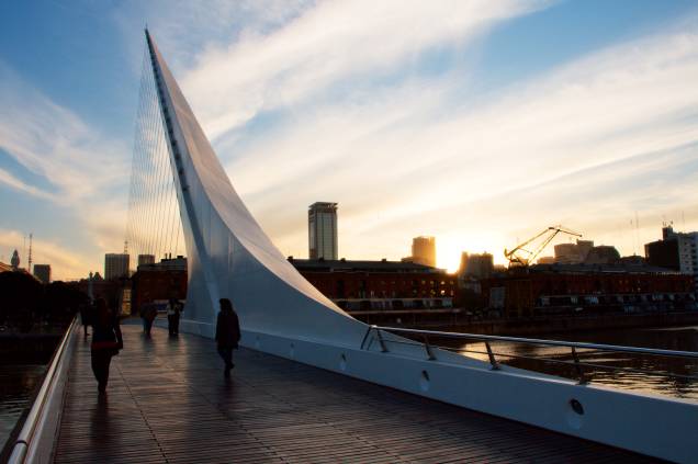 <strong>Puente de la Mujer </strong> Localizada no delicioso bairro de Puerto Madero, a ponte é nada menos que um ponto turístico obrigatório na cidade, sendo considerada um dos grandes símbolos da capital argentina. Sua arquitetura peculiar tem uma razão de ser: dizem que ela imita a imagem de uma mulher dançando tango. Vale a pena fazer uma pausa durante a noite, quando o lugar fica ainda mais bonito <strong>Puente de la Mujer </strong> Localizada no delicioso bairro de Puerto Madero, a ponte é nada menos que um ponto turístico obrigatório na cidade, sendo considerada um dos grandes símbolos da capital argentina. Sua arquitetura peculiar tem uma razão de ser: dizem que ela imita a imagem de uma mulher dançando tango. Vale a pena fazer uma pausa durante a noite, quando o lugar fica ainda mais bonito