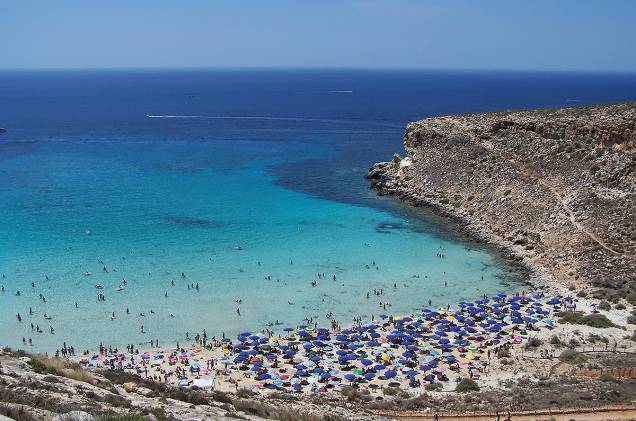 <strong>Rabbit-Beach</strong> A Rabbit Beach pertence à Ilha de Lampedusa, na costa sul da Sicília. O acesso à praia só é feito por barco. Essa é uma das poucas praias no mediterrâneo onde tartatugas colocam seus ovos e os turistas frequentam. Em 2013, ela levou o título de melhor do mundo! <em><a href="https://www.booking.com/searchresults.en-gb.html?aid=332455&lang=en-gb&sid=eedbe6de09e709d664615ac6f1b39a5d&sb=1&src=searchresults&src_elem=sb&error_url=https%3A%2F%2Fwww.booking.com%2Fsearchresults.en-gb.html%3Faid%3D332455%3Bsid%3Deedbe6de09e709d664615ac6f1b39a5d%3Bclass_interval%3D1%3Bdest_id%3D-111354%3Bdest_type%3Dcity%3Bdtdisc%3D0%3Bfrom_sf%3D1%3Bgroup_adults%3D2%3Bgroup_children%3D0%3Binac%3D0%3Bindex_postcard%3D0%3Blabel_click%3Dundef%3Bno_rooms%3D1%3Boffset%3D0%3Bpostcard%3D0%3Braw_dest_type%3Dcity%3Broom1%3DA%252CA%3Bsb_price_type%3Dtotal%3Bsearch_selected%3D1%3Bsrc%3Dindex%3Bsrc_elem%3Dsb%3Bss%3DBaunei%252C%2520%25E2%2580%258BSardinia%252C%2520%25E2%2580%258BItaly%3Bss_all%3D0%3Bss_raw%3DBauney%3Bssb%3Dempty%3Bsshis%3D0%26%3B&ss=Lampedusa%2C+%E2%80%8BSicily%2C+%E2%80%8BItaly&ssne=Baunei&ssne_untouched=Baunei&city=-111354&checkin_monthday=&checkin_month=&checkin_year=&checkout_monthday=&checkout_month=&checkout_year=&no_rooms=1&group_adults=2&group_children=0&highlighted_hotels=&from_sf=1&ss_raw=%C2%A0Lampedusa&ac_position=0&ac_langcode=en&dest_id=-119645&dest_type=city&place_id_lat=35.50353&place_id_lon=12.60669&search_pageview_id=0419903e64f60084&search_selected=true&search_pageview_id=0419903e64f60084&ac_suggestion_list_length=5&ac_suggestion_theme_list_length=0" target="_blank" rel="noopener">Busque hospedagens em Lampedusa no Booking.com</a></em>