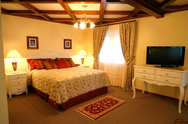 A suíte Provençal do hotel Ritta Höppner, em Gramado, possui cozinha com sala de jantar, cama king size, varanda para leitura e banheira de hidromassagem com cascata