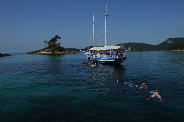 Barco ancorado nas Ilhas das Botinas, na Baia de Angra dos Reis (RJ). Com 365 ilhas, águas verdejantes e cheias de vida marina, Angra dos Reis (RJ) é um dos melhores lugares para mergulho do Brasil.