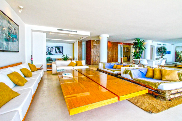 A ampla sala tem uma bossa moderna e minimalista, com colunas arredondadas e uma estética meio Niemeyer