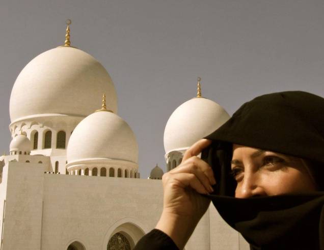 Mulher em frente à mesquita Sheikh Zayed, em Abu Dhabi nos Emirados Árabes Mulher em frente à mesquita Sheikh Zayed, em Abu Dhabi nos Emirados Árabes