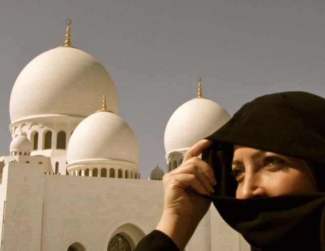 Mulher em frente à mesquita Sheikh Zayed, em Abu Dhabi nos Emirados Árabes