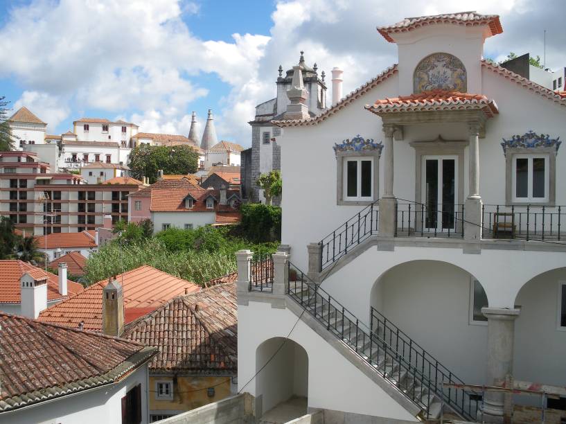 Se chegar à <strong>Sintra </strong>no começo da manhã, é possível que você vá encontrar a cidade coberta de neblina, com as chaminés do Palácio de Sintra à mostra lá no alto. Com o passar do dia, a neblina se dissipa e revela as abóbadas arredondadas do <strong>Palácio da Pena</strong>, as casas coloridas e a rica natureza ao redor da cidade. Devido à sua proximidade com Lisboa, Sintra é uma boa alternativa para um bate-e-volta – seja de carro ou de trem (que os portugueses chamam de comboio)