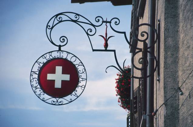 Cruz da bandeira suíça sinaliza a entrada de um café-restaurante em Genebra