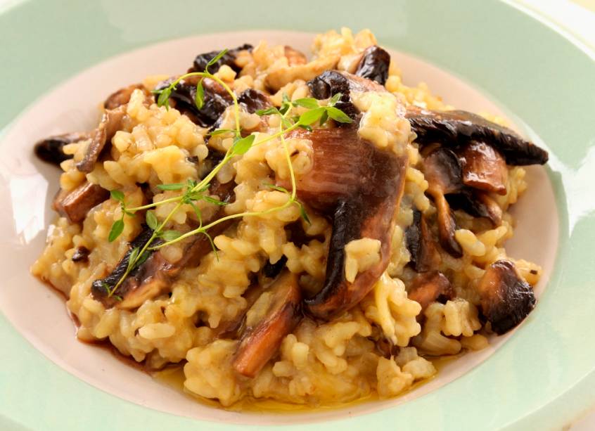 <strong>Risotto, <a href="https://viajeaqui.abril.com.br/paises/italia" rel="Itália" target="_blank">Itália</a></strong><br />  Clássico acompanhamento de pratos principais em boa parte dos países, o arroz aqui é o rei. De consistência cremosa, al dente e contando com sabores variados, é um primeiro prato certeiro. Ao <strong>arroz</strong> – normalmente <strong>arbório</strong> – cozido lentamente ao vinho e caldo, acrescenta-se ingredientes diversos. <em>Funghi secchi</em>, ervilhas e frutos do mar estão entre as variantes favoritas, quase todas finalizadas com uma boa dose de manteiga que oferece sabor e brilho. Duas receitas bem populares são a de tinta de sépia, encontrada em <a href="https://viajeaqui.abril.com.br/cidades/italia-veneza" rel="Veneza" target="_blank">Veneza</a>, e a milanesa, amarelada pelo açafrão.