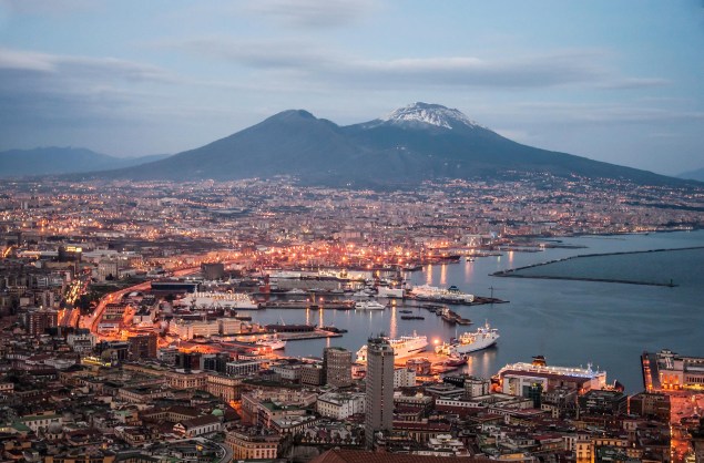 A vista da baía e do porto de <a href="https://viajeaqui.abril.com.br/cidades/italia-napoles" rel="Nápoles">Nápoles</a>, com o Vesúvio ao fundo, é uma das mais belas da cidade