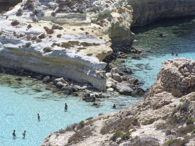 <strong>Isola dei Conigli, Sicília, <a href="http://viajeaqui.abril.com.br/paises/italia" rel="Itália" target="_self">Itália</a></strong>                Localizada na emblemática ilha de Lampedusa, a praia é ótima para mergulho, com suas águas mornas e calmas. O acesso é complexo, feito a partir de uma íngreme trilha de pedras. Mas a tranquilidade proporcionada pela região compensa o esforço, além de oferecer uma paisagem paradisíaca                <em><a href="http://www.booking.com/city/it/lampedusa.pt-br.html?sid=5b28d827ef00573fdd3b49a282e323ef;dcid=1?aid=332455&label=viagemabril-as-mais-belas-praias-do-mediterraneo" rel="Veja preços de hotéis próximos à Isola dei Conigli no Booking.com" target="_blank">Veja preços de hotéis próximos à Isola dei Conigli no Booking.com</a></em>