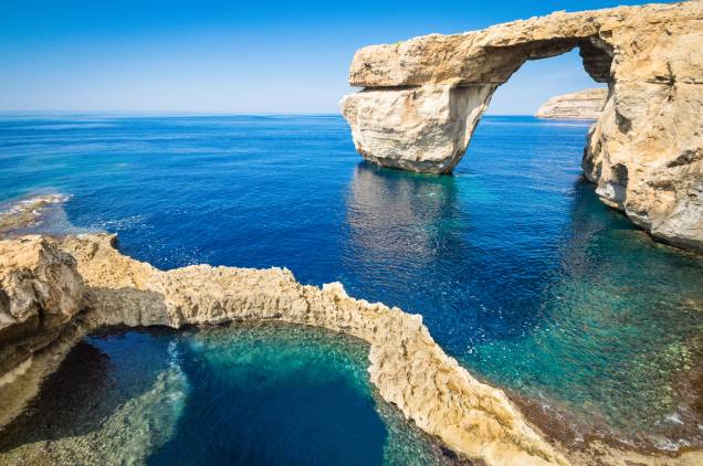 <strong>Ilha de Gozo, <a href="http://viajeaqui.abril.com.br/paises/malta" rel="Malta" target="_self">Malta</a></strong>                Considerada a segunda maior ilha do arquipélago de Malta, Gozo impressiona com suas formações rochosas de <strong>Azure Window</strong>, praticamente uma janela para quem as visita, dando uma visão incrível do mar, sobretudo no pôr do sol. No entorno das praias, há cenários bucólicos e charmosos – ideal pra quem procura sossego                <em><a href="http://www.booking.com/region/mt/gozo-comino.pt-br.html?sid=5b28d827ef00573fdd3b49a282e323ef;dcid=1?aid=332455&label=viagemabril-as-mais-belas-praias-do-mediterraneo" rel="Veja preços de hotéis na Ilha de Gozo no Booking.com" target="_blank">Veja preços de hotéis na Ilha de Gozo no Booking.com</a></em>