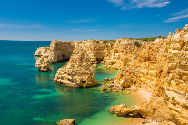 <strong>Praia da Marinha, Algarve, <a href="http://viajeaqui.abril.com.br/paises/portugal" rel="Portugal" target="_self">Portugal</a></strong>                O título não é brincadeira: é uma das mais belas e emblemáticas praias do país, além de já ter sido eleita pelo Guia Michelin como uma das cem praias mais bonitas do mundo. Sua encosta é formada por falésias, marcando a beleza de águas cristalinas perfeitas para mergulho. Seu acesso é feito por uma escadaria, de onde se pode observar a vegetação de tomilhos silvestres                <em><a href="http://www.booking.com/city/pt/carvoeiro.pt-br.html?sid=5b28d827ef00573fdd3b49a282e323ef;dcid=1?aid=332455&label=viagemabril-as-mais-belas-praias-do-mediterraneo" rel="Veja preços de hotéis próximos à Praia da Marinha no Booking.com" target="_blank">Veja preços de hotéis próximos à Praia da Marinha no Booking.com</a></em>