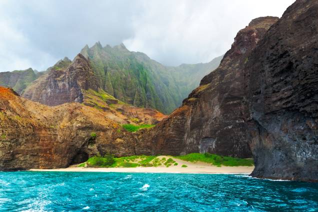 <strong>Costa de Na Pali – Havaí, <a href="http://viajeaqui.abril.com.br/paises/estados-unidos" rel="EUA" target="_blank">EUA</a></strong>                                                                                                                                                            São 35 quilômetros de penhascos verdejantes à beira do incrível mar havaiano. As montanhas na região de Kauai escondem a rica fauna e flora do Havaí, abrigando espécies raras, aves tropicais e cachoeiras secretas