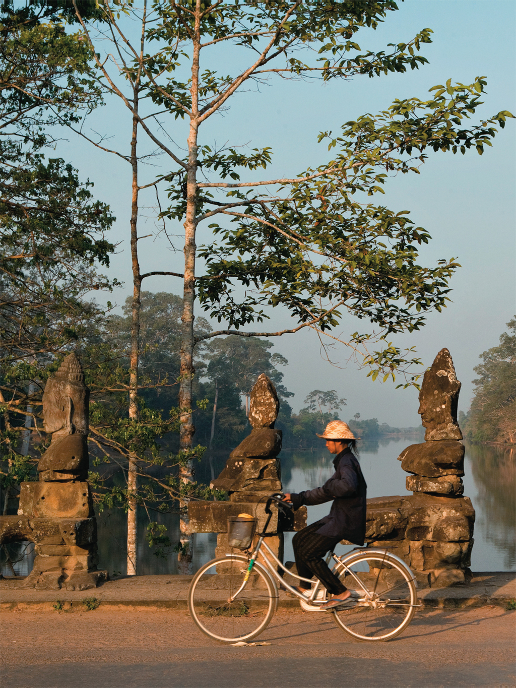 Ciclista na ponte de Angkor Thom, no Camboja