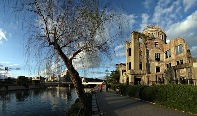 O antigo Hall de Promoção Industrial de Hiroshima, junto ao rio Ota, encontrava-se próximo ao epicentro da explosão atômica. Um dos poucos edifícios da área a sobreviver à bomba, cogitou-se sua demolição após a guerra. Hoje ela é uma testemunha silenciosa dos horrores daquele tempo e uma mensagem poderosa a políticos de todo o mundo O antigo Hall de Promoção Industrial de Hiroshima, junto ao rio Ota, encontrava-se próximo ao epicentro da explosão atômica. Um dos poucos edifícios da área a sobreviver à bomba, cogitou-se sua demolição após a guerra. Hoje ela é uma testemunha silenciosa dos horrores daquele tempo e uma mensagem poderosa a políticos de todo o mundo