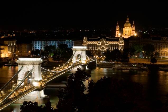 A ponte suspensa Szechenyi é uma das principais ligações entre Buda e Peste. Batizada em nome do estadista István Szécheny, foi a primeira ligação permanente na capital húngara e, à época de sua inauguração, era uma das mais longas do mundo. Ao fundo, com sua cúpula iluminada, encontra-se a Catedral de Santo Estevão