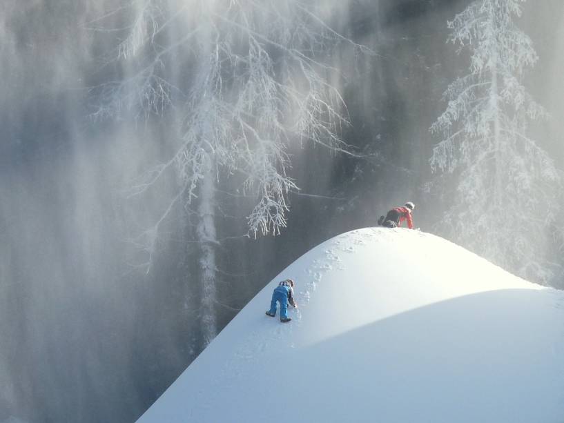 Crianças brincando em um monte de neve em Val Gardena 