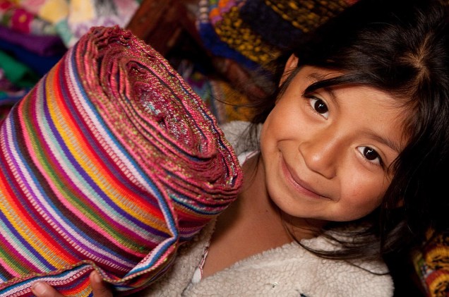 Garota prepara tecidos em fábrica de Chichicastenango, Guatemala