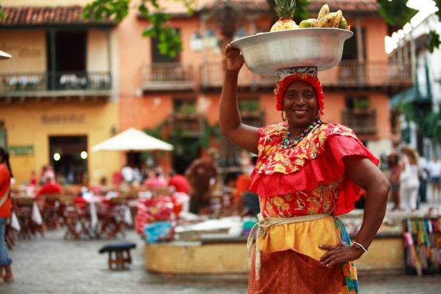 As vendedoras de frutas, chamadas de palenqueras, percorrem as ruas da cidade com seus vestidos coloridos e bacias na cabeça