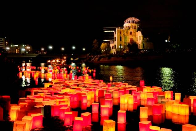 Lanternas com mensagens de paz no rio Ota. Ao fundo, o domo da bomba de Hiroshima Lanternas com mensagens de paz no rio Ota. Ao fundo, o domo da bomba de Hiroshima
