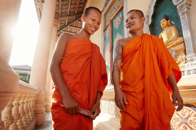 Monges sorridentes passeiam pelos palácios e templos da cidade