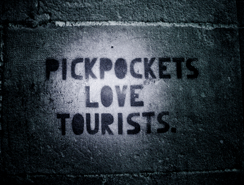 Stêncil na parede com a frase 'Pickpockets love tourists' - batedores de carteiras amam turistas