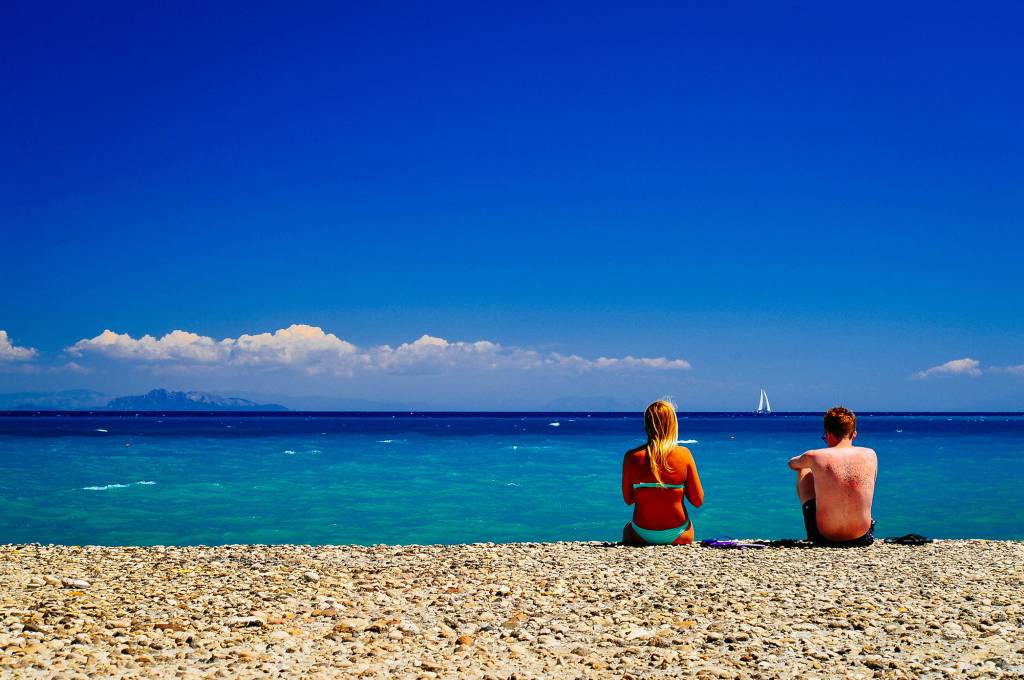 Casal de turistas em praia da Grécia