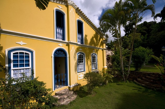 Fachada e jardim lateral da Alcino Estalagem & Atelier, em Lençóis, casarão de 1890 restaurado e transformado em pousada