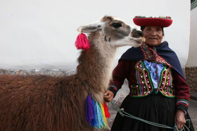 Mulher com trajes típicos do Peru com uma lhama